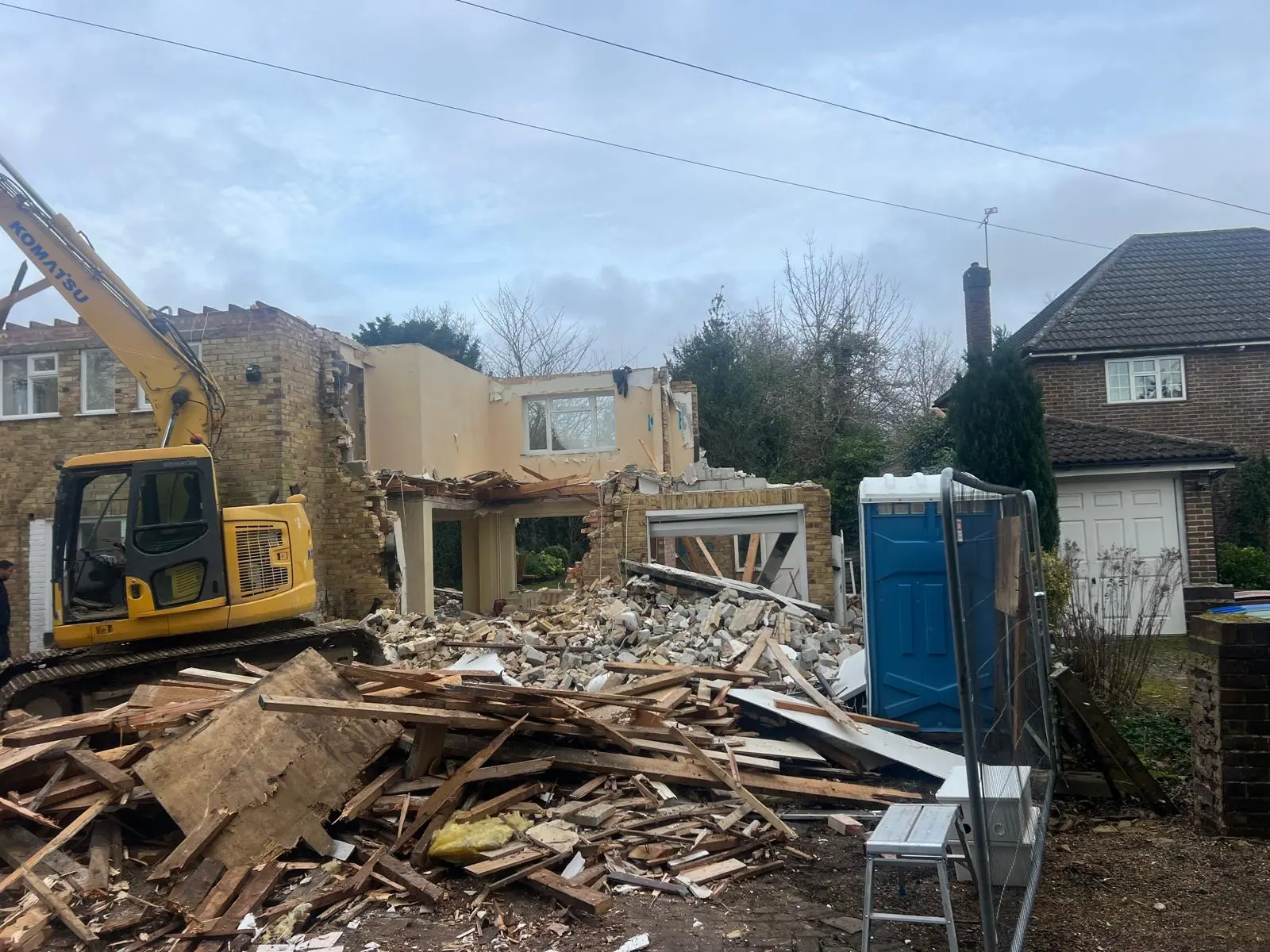 Controlled residential demolition with excavator